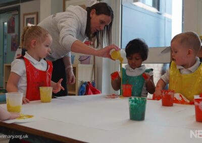 Toddlers enjoying messy play with paint and water at Whitehouse Primary Stay and Play session.